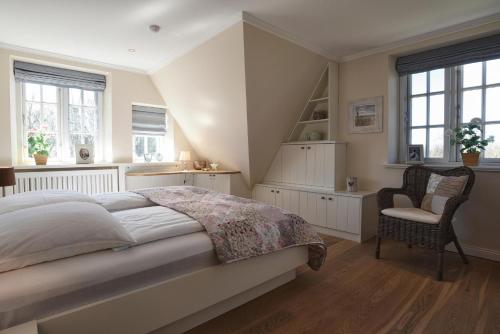 博尔格苏姆Friesenliebe的一间卧室配有一张床、一把椅子和窗户。