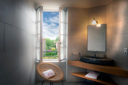 MontpeyrouxThe view of Montpeyroux的一间带水槽的浴室和一个带镜子的窗户
