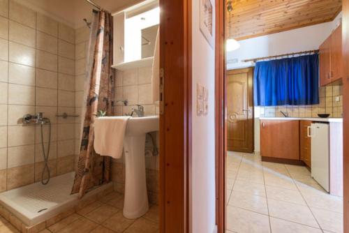 瓦西里科斯雅典娜公寓的带淋浴、盥洗盆和浴缸的浴室