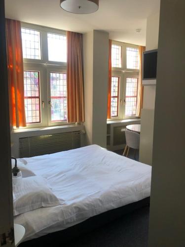 布鲁日萨尔瓦托酒店的卧室配有白色的床和窗户。