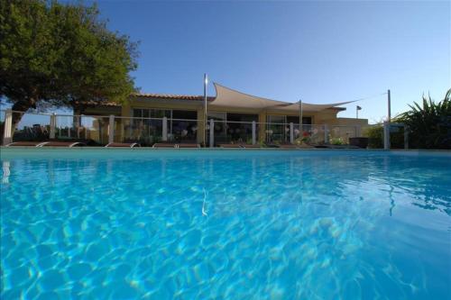 卡尔维location de vacances figuier avec jardin barbecue piscine chauffée à Calvi的大楼前的大型游泳池
