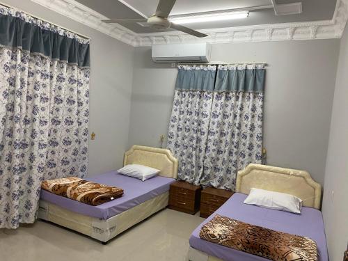 阿尔哈姆拉Dar ALHamra Inn的配有窗帘的客房内的两张床