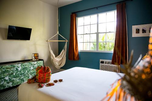 圣胡安Numero Uno Beach Apartments的一间卧室设有一张床、一个窗口和吊床