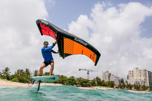 圣胡安Numero Uno Beach Apartments的一个人站在水面上的冲浪板上