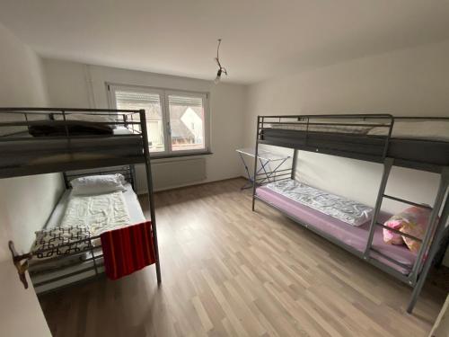 巴特塞京根Tokis Feriendomizil 2.0的客房设有三张双层床,铺有木地板。