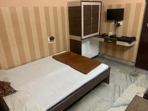 古瓦哈提Hotel Prince的一间卧室配有一张床和一张书桌及电视