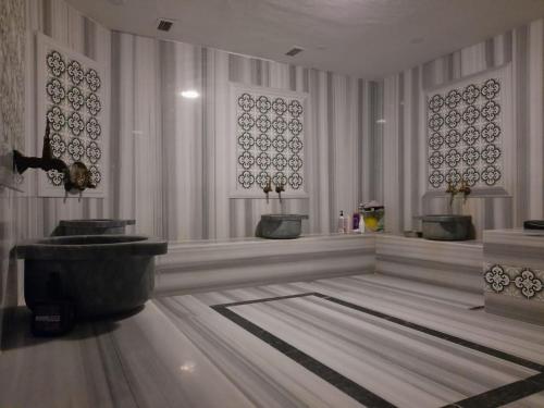 迪亚巴克尔迪亚巴克尔广场酒店的浴室配有两个盥洗盆和浴缸。