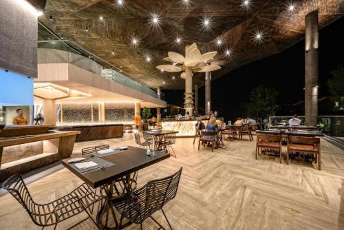 蔻立Kalima Resort and Villas Khao Lak - SHA EXTRA PLUS的一间带桌椅的餐厅和一间酒吧