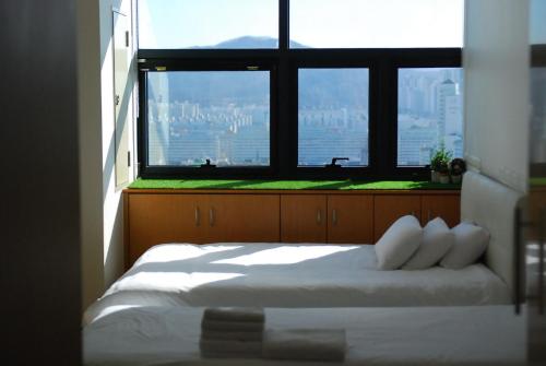 首尔Samseong Coexmall AA的一间卧室设有一张床和一个大窗户