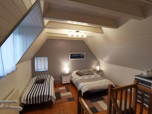 桑泰克Gîte bord de mer的阁楼间 - 带两张床和窗户
