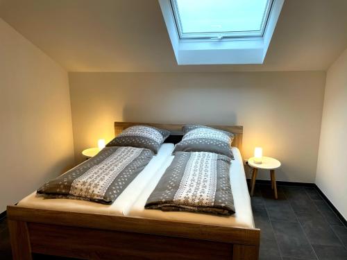 克尔贝格Gästehaus Veenstra的一间卧室配有两张带枕头的床和窗户。