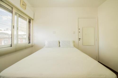 圣保罗Apartamento aconchegante com estacionamento na 25 de março的白色的客房内的一张大白色床,设有窗户
