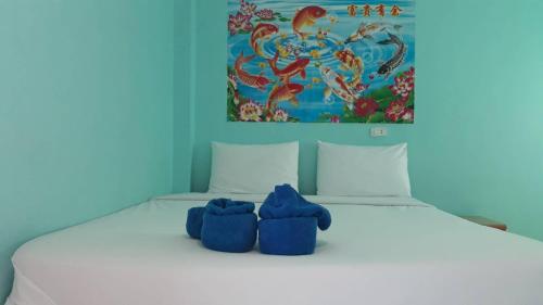 卡农卡农斯特拉度假旅馆的床上有两只蓝色填充物的动物