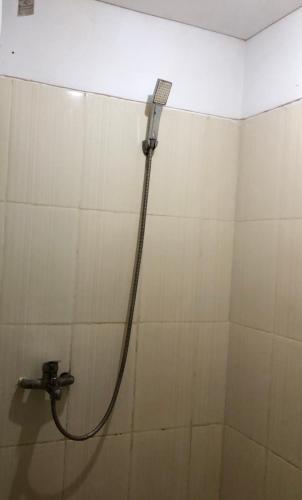 玛琅Apartemen Malang的墙上的软管淋浴