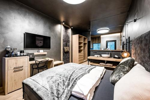 瓦格赖恩ALMMONTE PRÄCLARUM SUITES Design Hotel的一间卧室配有一张床,并在一间客房内配有电视。
