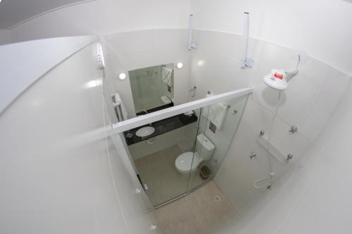 瓜鲁雅Asturias Mall & Suítes的白色的浴室设有卫生间和镜子