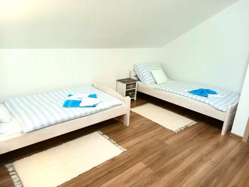 斯祖贝莱克Apartmán pod Sivým vrchom的铺有木地板的客房内的两张床