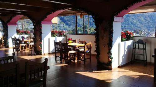 Xicotepec de JuárezHotel Villa de Cortez的用餐室设有桌椅和窗户。