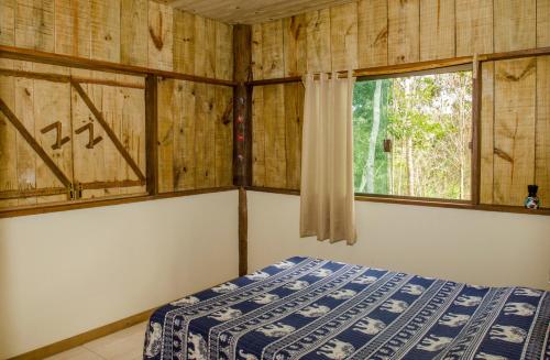 大塞拉Sitio recanto da natureza的一间卧室设有一张床和一个窗口
