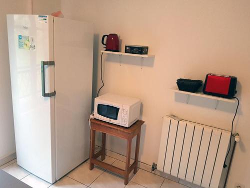 Saint-Sernin-du-PlainGîte Santenay les Bains的冰箱旁的桌子上有一个微波炉