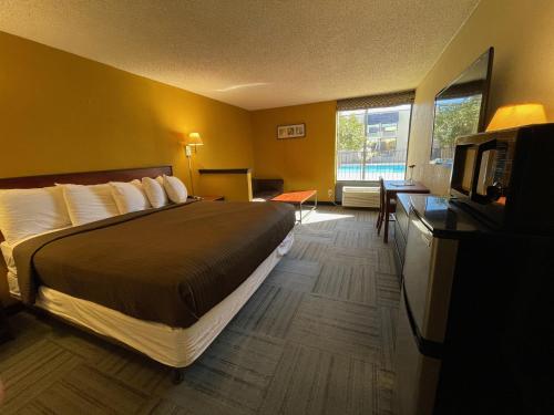 阿比林Abilene Whitten Inn的配有一张床和一台平面电视的酒店客房