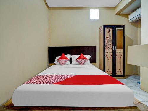 CikampekOYO Capital O 90081 Pondok Sabaraya 2 Syariah的一间卧室配有一张带红色枕头的大床
