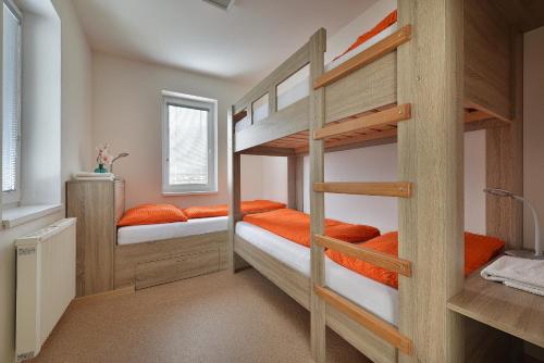 伏尔塔瓦河畔利普诺Rekreační domek Kobylnice Lipno的带两张双层床的客房配有橙色枕头