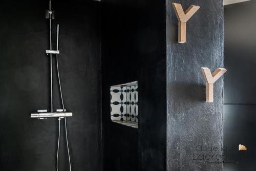 马尔什昂法梅讷La Luciole Gîte urbain à Marche en Famenne的黑色浴室设有木把手淋浴