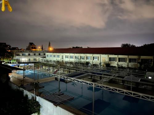 保禄Khách sạn Nguyên Long的一座建筑,在晚上前方有一个游泳池