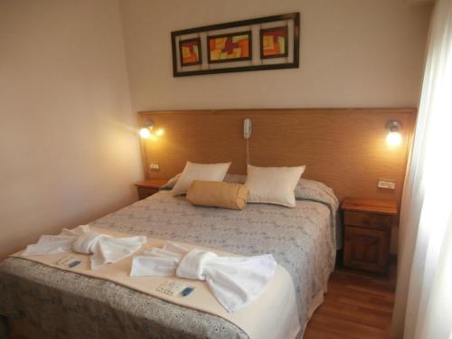 马德普拉塔Hotel Alma di Mare的一间卧室配有一张床,上面有两条毛巾