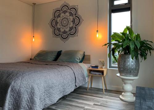 奥斯特沃尔德Mooiverblijf的一间卧室配有一张床和盆栽植物