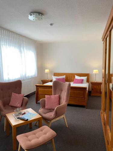 宾茨马里昂旅馆的酒店客房配有一张床、两把椅子和一张桌子
