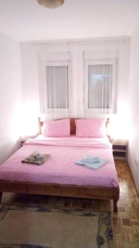 Gornja ToplicaApartman Jevtić 2的一间卧室配有一张带粉红色床单的大床