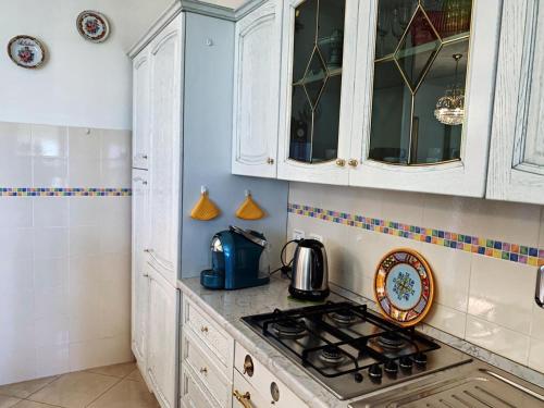 帕尔马Casa di Alice的厨房配有白色橱柜和炉灶烤箱。