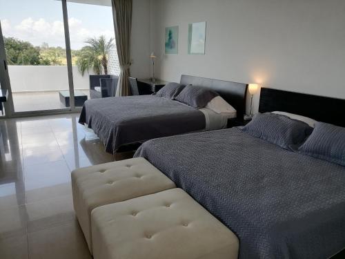 普拉亚布兰卡Town Center Playa Blan的酒店客房,设有两张床和一张沙发