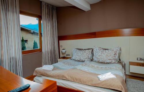 多布里尼什特Luxury houses in Dobrinishte的一间卧室配有一张带书桌的床和窗户。