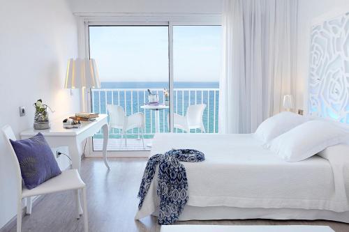普拉加德阿罗Hotel Planamar by Escampa Hotels的一间带一张床和一张书桌的卧室以及一个阳台
