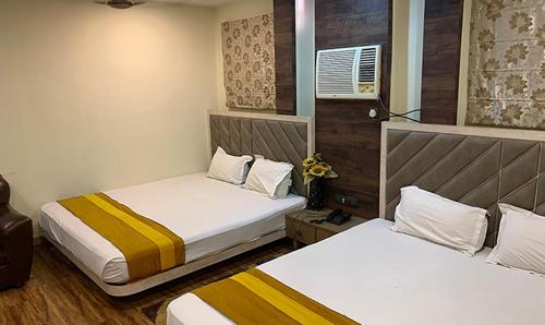 加尔各答Shila International的小客房内的两张床,配有两张sidx sidx单人床