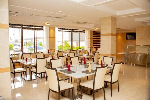 卢萨卡HOTEL AFRICANA LSK的餐厅设有桌椅和窗户。