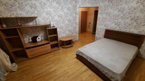 乌法комфортная 2 комнатная квартира возле Аквапарка на Комсомольской 148的一间卧室配有一张床,铺有木地板