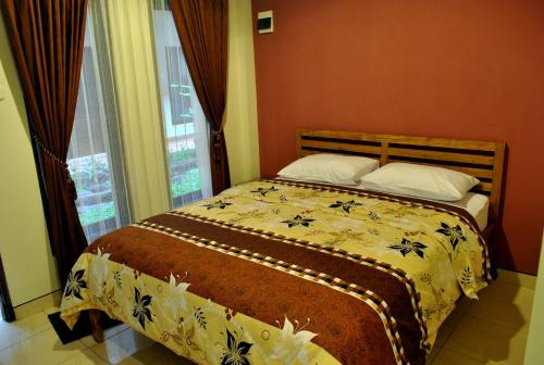 日惹日惹阿罗哈酒店的一间卧室设有一张床和一个窗口