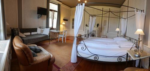 斯帕L'Étape Fagnarde - Bed, Breakfast & Sauna的一间带天蓬床的卧室和一间客厅
