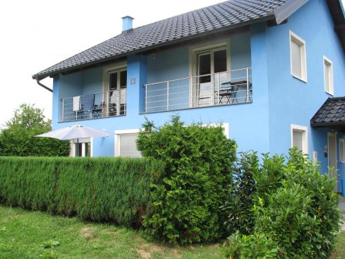 PotokVilla Plavi Lav Potok的带阳台和遮阳伞的蓝色房屋