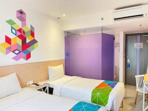 雅加达Dafam Express Jaksa Jakarta的一间设有两张床的客房,墙上挂着一幅画