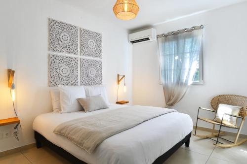 东方湾Orient Bay Beach Front Apartment的卧室设有一张白色大床和一扇窗户。