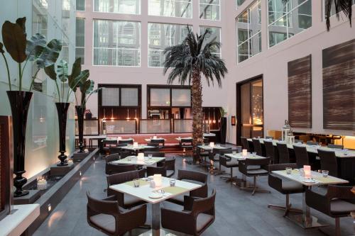 迪拜罗纳塔阿拉巴沙中心酒店的一间设有桌椅的餐厅,并种植了棕榈树