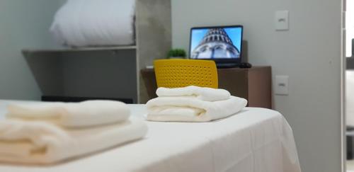 乌贝兰迪亚Aero Inn Hotel的桌子上的两条毛巾和黄椅