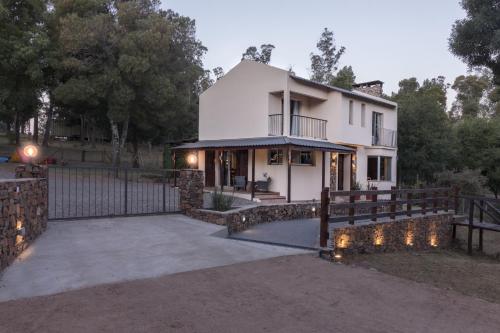 米纳斯Posada La Serena的白色的房子,有栅栏和车道