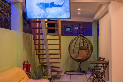 OmadhooTurtle Maldives - Your Gateway to the Beach & Marine Adventures Await!的客房设有吊床和电视。