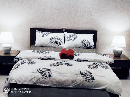 努沙再也Kumkum Homestay Studio的一间卧室配有一张带两盏灯和红色鞋的床